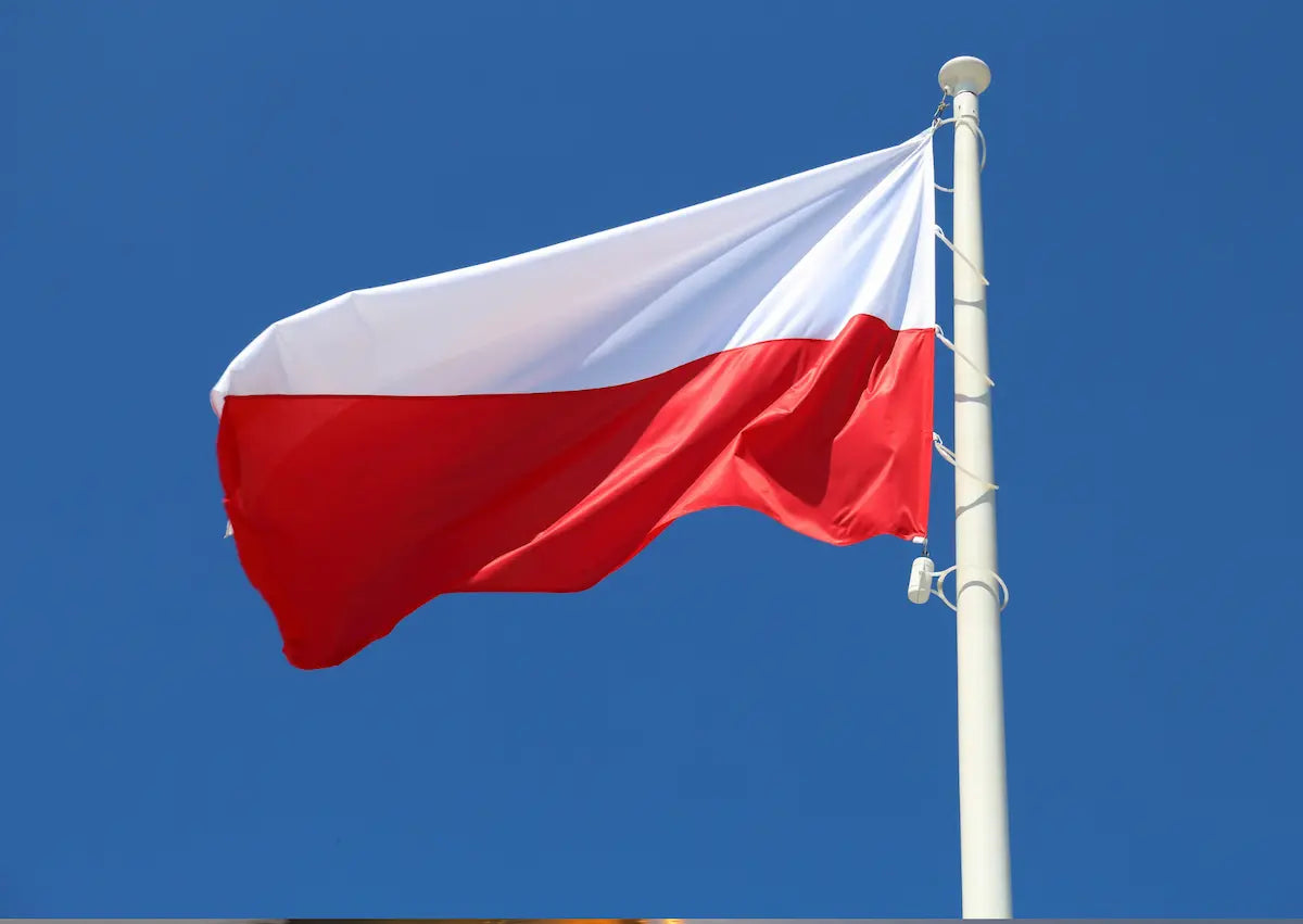 Die polnische Nationalflagge in Weiß und Rot weht an einem weißen Mast vor blauem Himmel – Zur digitalen Maut Polen (e-TOLL) auf mautbox24.com.